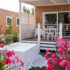 Casa vacanze con terrazza, vasca e fiori rosa.