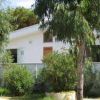 Casa bianca circondata da alberi e cespugli verdi.