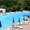 Piscina all'aperto con lettini e ombrelloni blu.