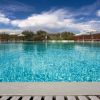 Una piscina con ombrelloni e cielo blu.