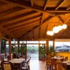 Sala da pranzo luminosa con tavoli e sedie in legno.