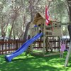 Bambina al parco giochi con scivolo blu.