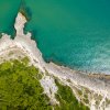 Vista aerea di una costa rocciosa e mare turchese.