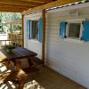 Veranda con tavolo di legno e finestre azzurre.