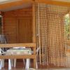 Casetta in legno con tenda a fili e tavolo esterno.