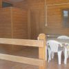 Tavolo con sedie bianche su veranda di legno.