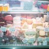 Vetrina di salumi e formaggi assortiti in un negozio.
