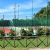 Campi da tennis vuoti circondati da recinzione.