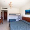 Camera con letto matrimoniale, letto a castello e scrivania.