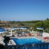 Piscina con lettini e ombrelloni blu e bianchi.