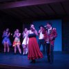 Performance di gruppo su un palco di legno.