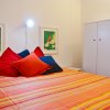 Letto colorato con cuscini e quadri.