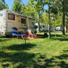 Camper con sedie e tavolo su prato verde.