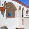 Balcone con archi e piante in vaso.