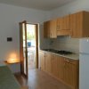 Cucina con mobili in legno e frigorifero.