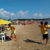 Spiaggia affollata con ombrelloni e sedie.