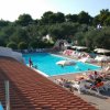 Piscina all'aperto con lettini e ombrelloni.