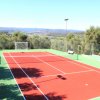 Campo da tennis con sfondo collinare.