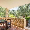 Terrazza con tavolo e vista su un giardino d'ulivi.