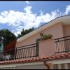 Balcone di casa con tetto spiovente e cielo sereno.