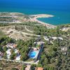 Veduta dall'alto di un'area costiera con piscine e spiagge sabbiose.