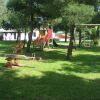 Area giochi con scivolo, altalene e bilico.