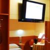 Camera d'hotel con TV a schermo piatto e due letti.