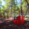 Altalena e giochi per bambini in un parco alberato.