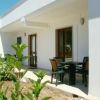 Veranda con tavolo e sedie, affaccio su giardino curato.