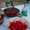 Tavola con pomodori, olive e pane, decorata con fiori.