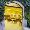 Entrata di un ristorante con vetrata e piante rampicanti.