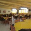 Una sala da pranzo con tavoli apparecchiati in giallo.