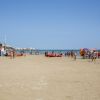 Spiaggia affollata con ombrelloni colorati.