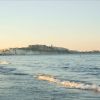 Spiaggia con mare calmo al tramonto.