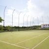 Un campo da tennis all'aperto con rete e recinzione.
