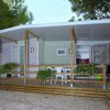 Bungalow con veranda in legno e piante appese.