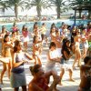 Persone che ballano in gruppo a bordo piscina.