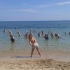 Persone che fanno esercizi in acqua in spiaggia.
