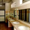 Bagni pubblici con file di lavandini e specchi.