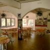 Sala da pranzo con tavoli e sedie bianchi.