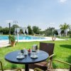 Tavolino con caffè vicino a una piscina in un giardino verde.