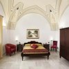 Camera da letto con soffitto a volta, letto matrimoniale, armadio scuro e sedia rossa.