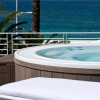 Una vasca idromassaggio su una terrazza con vista sul mare e palme.